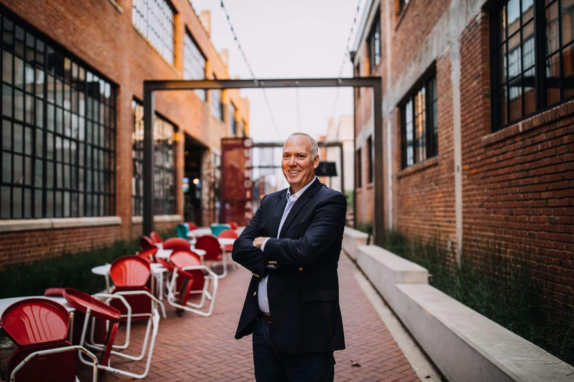 JK standing in a brick-lined urban courtyard
